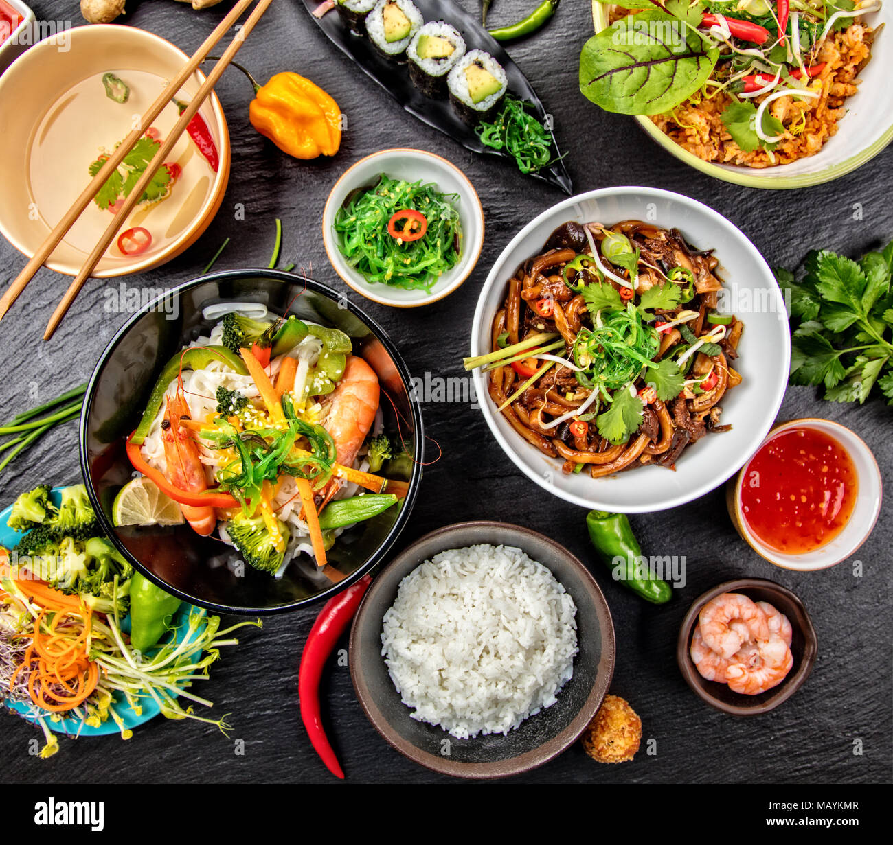 Asiatische Lebensmittel Variation mit vielen Arten von Mahlzeiten. Kari Reis, Nudeln und Gemüse. Ansicht von oben, auf schwarzen Stein serviert. Stockfoto