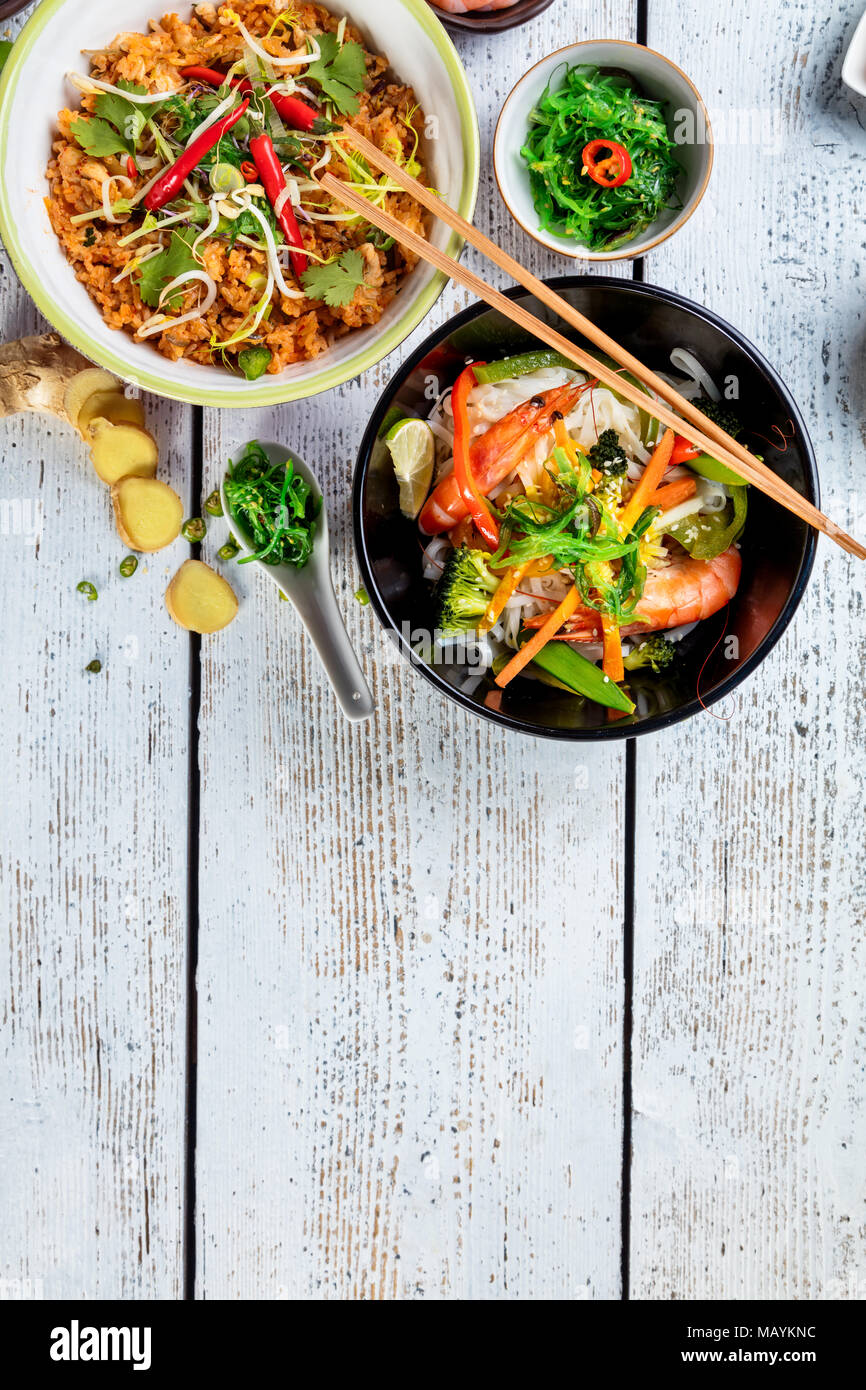 Asiatische Huhn und Garnelen Curry mit Reis und frisches Gemüse, Ansicht von oben, auf alten Holzbrettern serviert. Stockfoto
