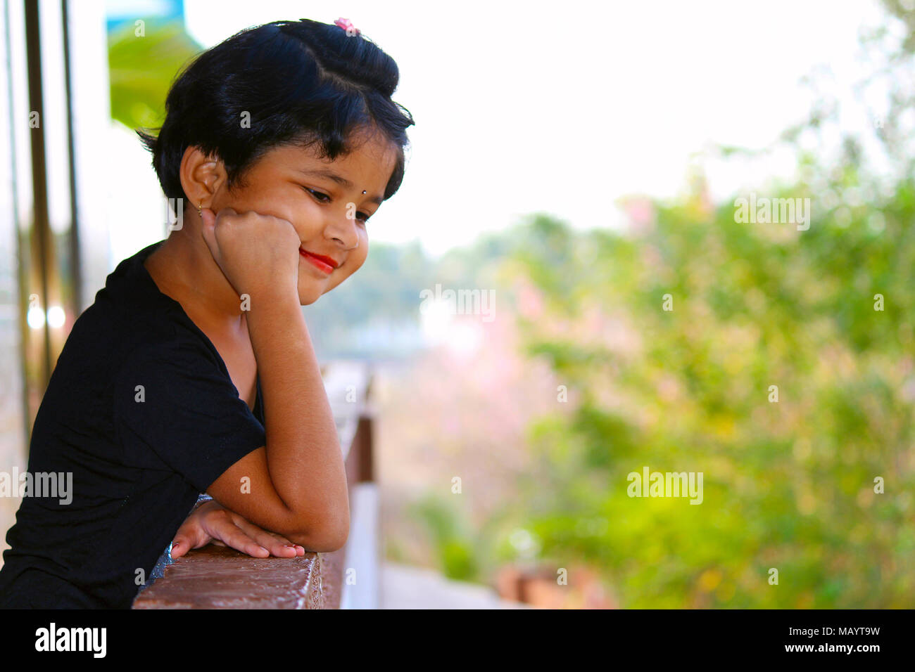 Kleines Mädchen den Blick vom Balkon mit einem Lächeln auf ihrem Gesicht an Palande, Kokan Stockfoto