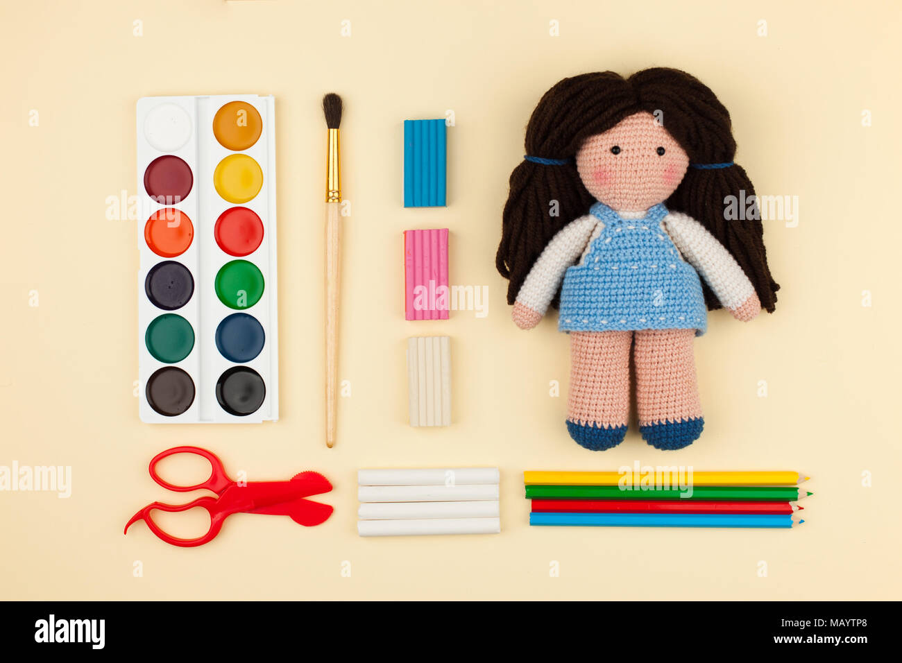 Oder Puppe mit braunen Haaren, Aquarelle, Bürsten Papier auf einem gelben Hintergrund, das Konzept von Urlaub, Kreativität und die Entwicklung der Kinder Stockfoto