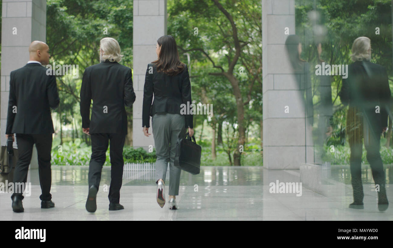 Multinationale Unternehmen Unternehmer und Geschäftsfrau verlassen zu Fuß aus modernen Bürogebäude. Stockfoto