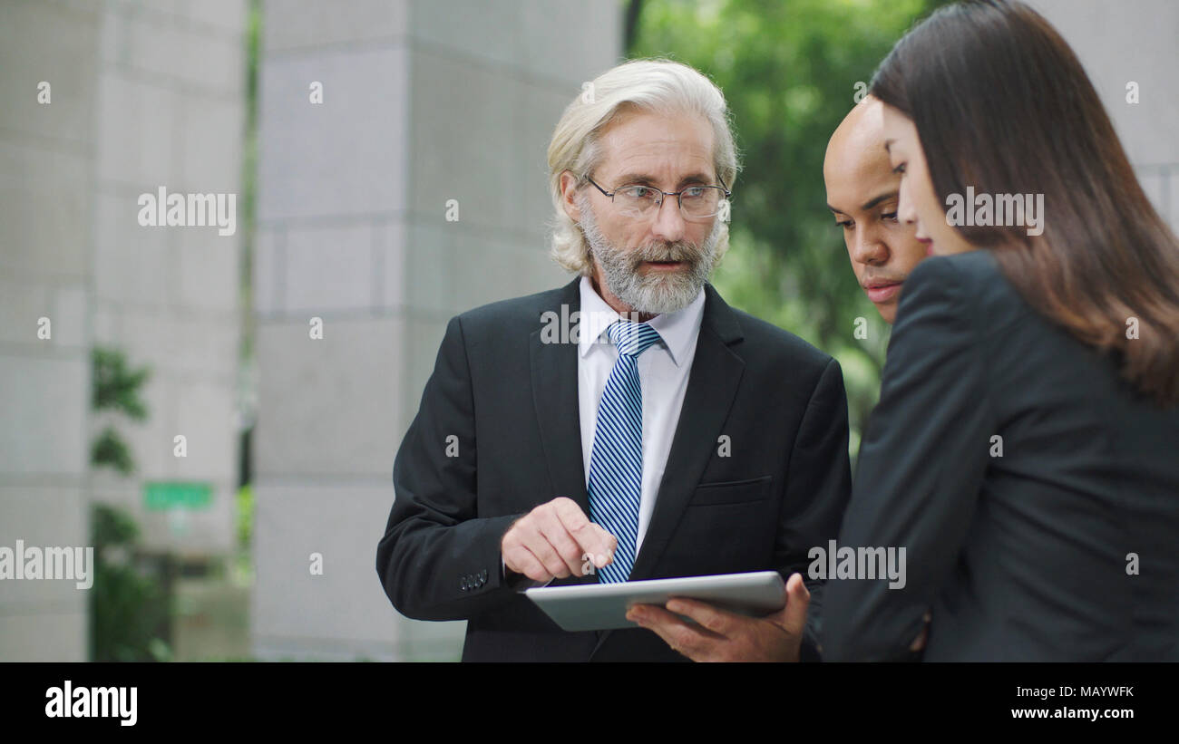 Multinationale Unternehmen Führungskräfte diskutieren Geschäft mit digitalen Tablet. Stockfoto