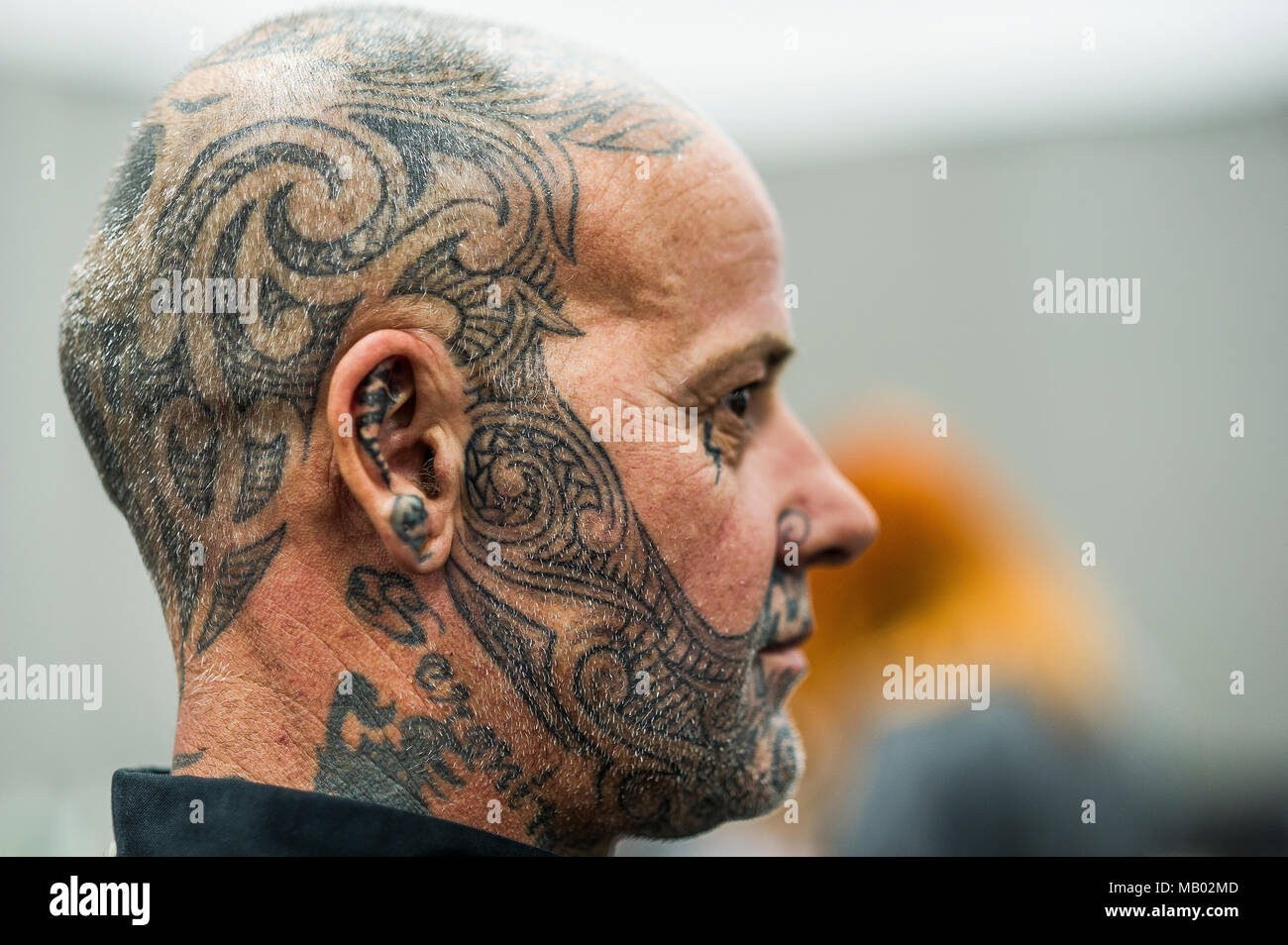 Ein Mann mit einem TÄTOWIERTEN Gesicht und Kopf in Cornwall Tattoo Convention. Stockfoto