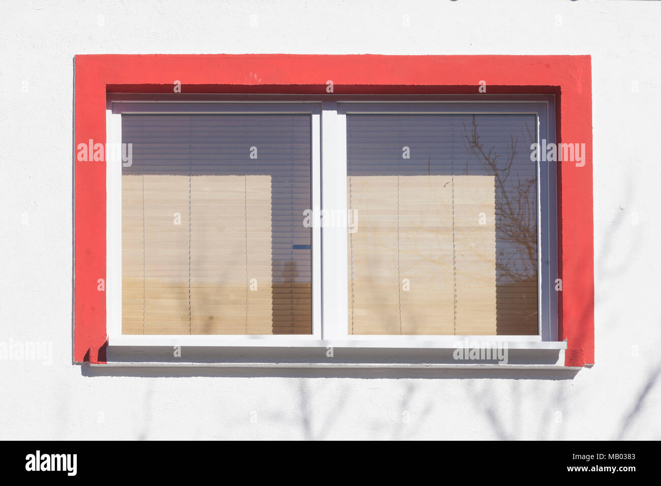 Rot umrandeten Fenster mit Fensterläden auf weißen Hauswand, Bremen, Deutschland, Europa ich rot umrandetes Fenster mit Rolläden heruntergezogenen eine weiss Stockfoto