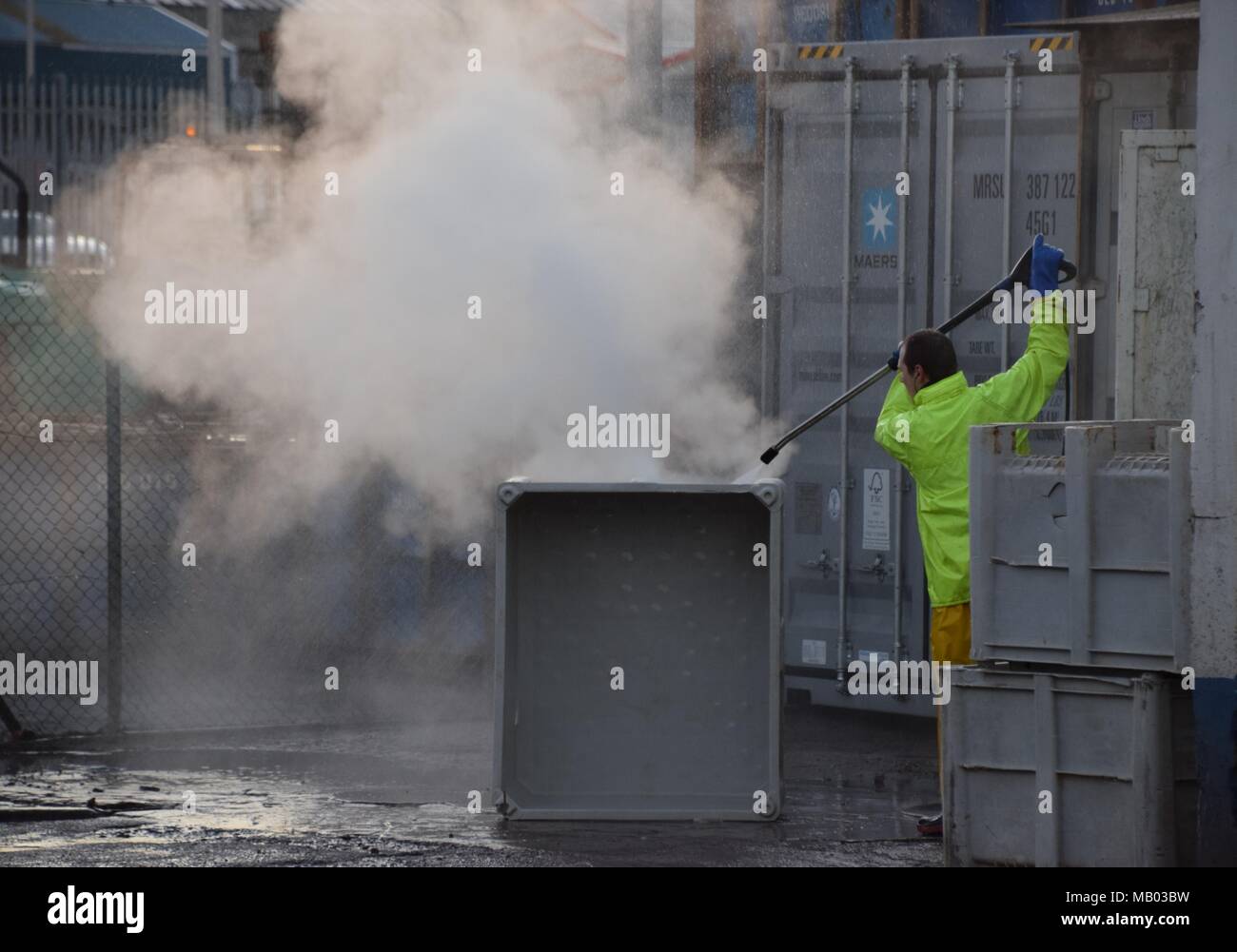 Mann bei der Arbeit Dampfreinigung fishboxes in Torry, Aberdeen Stockfoto