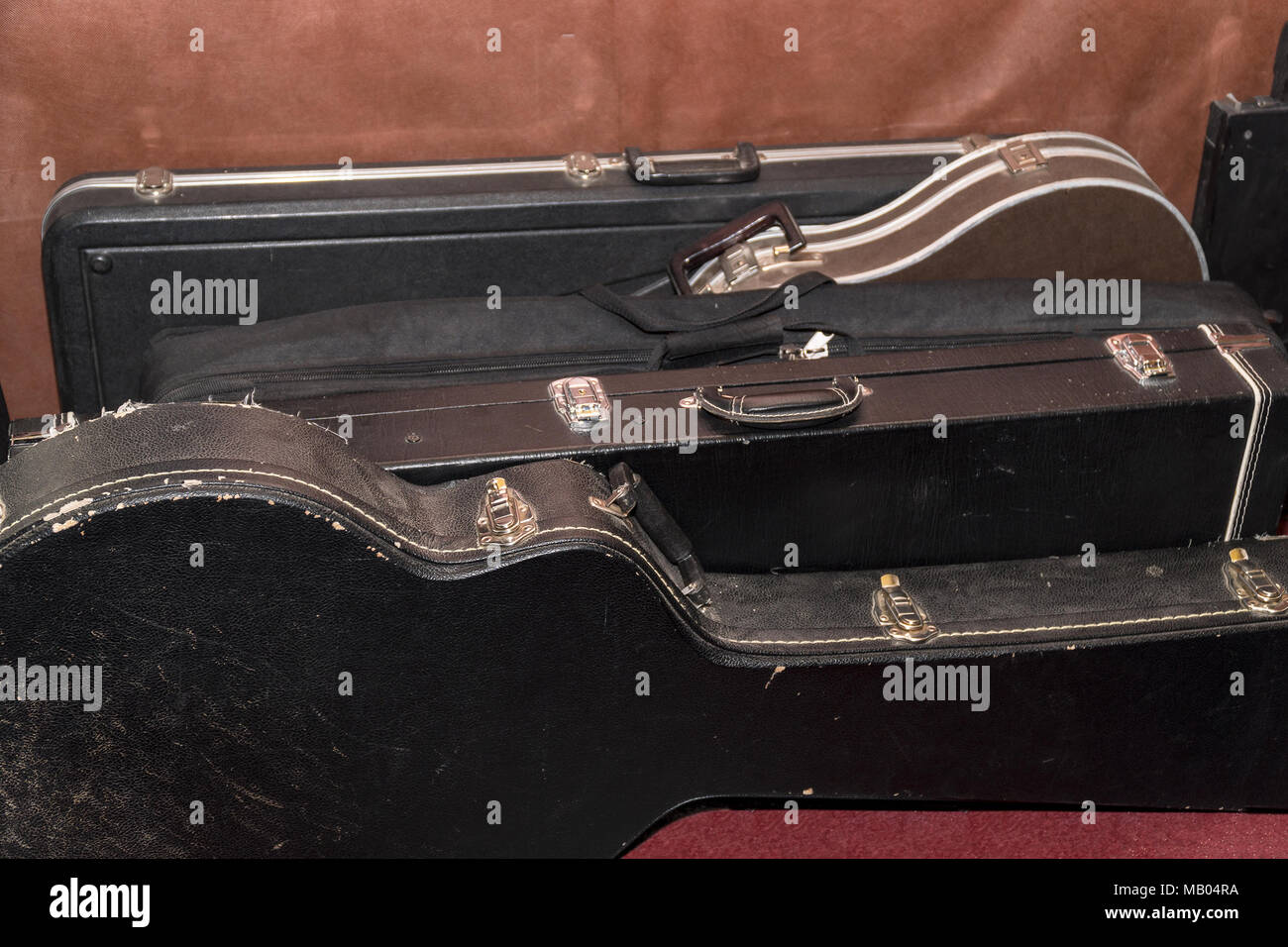 Harte Fälle für Gitarren sind an der Wand Stockfoto