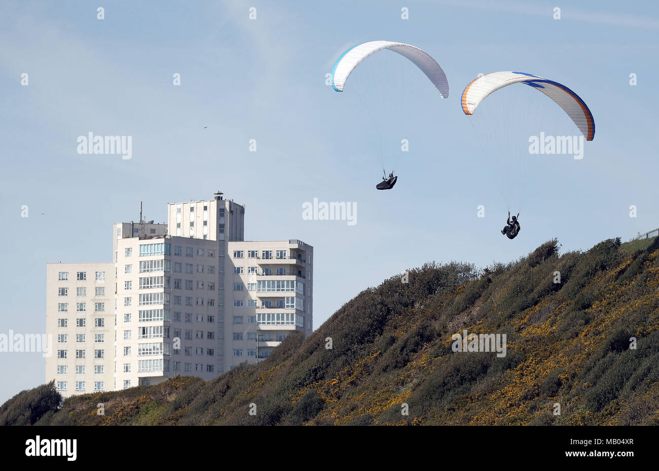 Zwei para Segelflugzeuge machen ihren Weg entlang der East Cliff über Boscombe Strand in Bournemouth, Dorset. Stockfoto