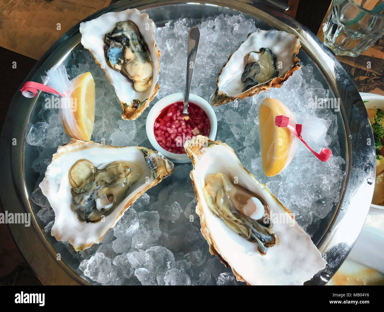 Eine große Platte mit delikatesnye Austern auf Eis mit Kalk mit ... Eine große Platte mit delikatesnye Austern auf Eis mit Kalk mit ...