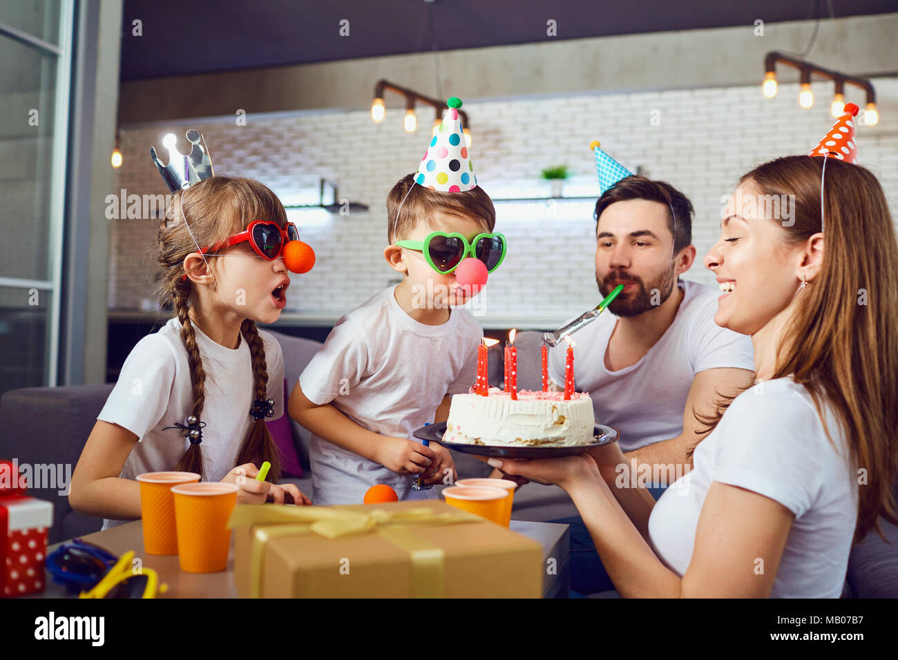 Eine glückliche Familie mit einem Kuchen feiert Geburtstag. Stockfoto