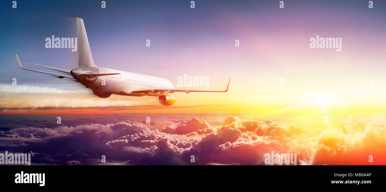 Flugzeug über den Wolken bei Sonnenaufgang fliegen Stockfoto