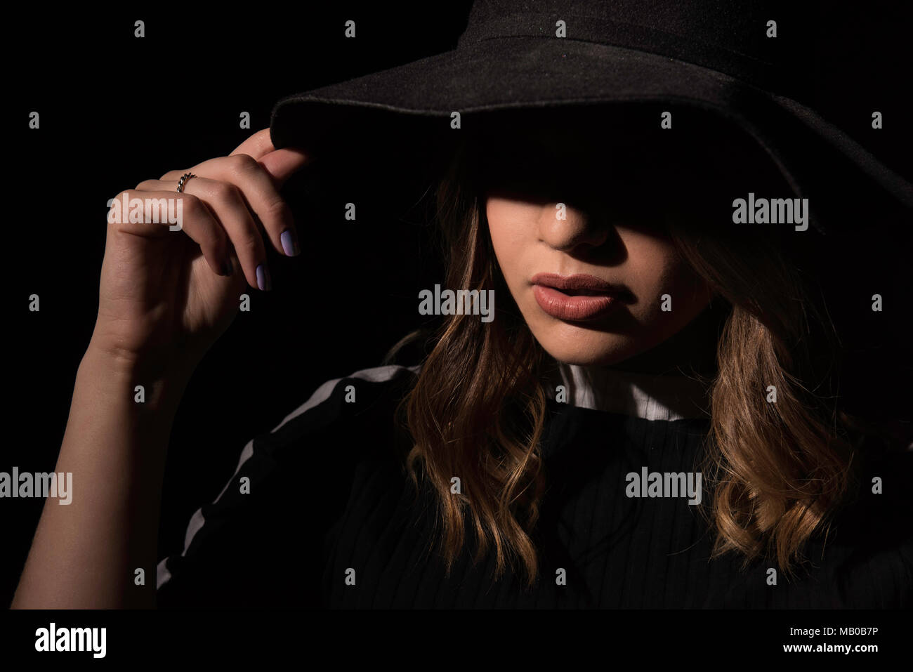 Geheimnisvolle Frau verborgen im Schatten tragen einen schwarzen Hut Stockfoto