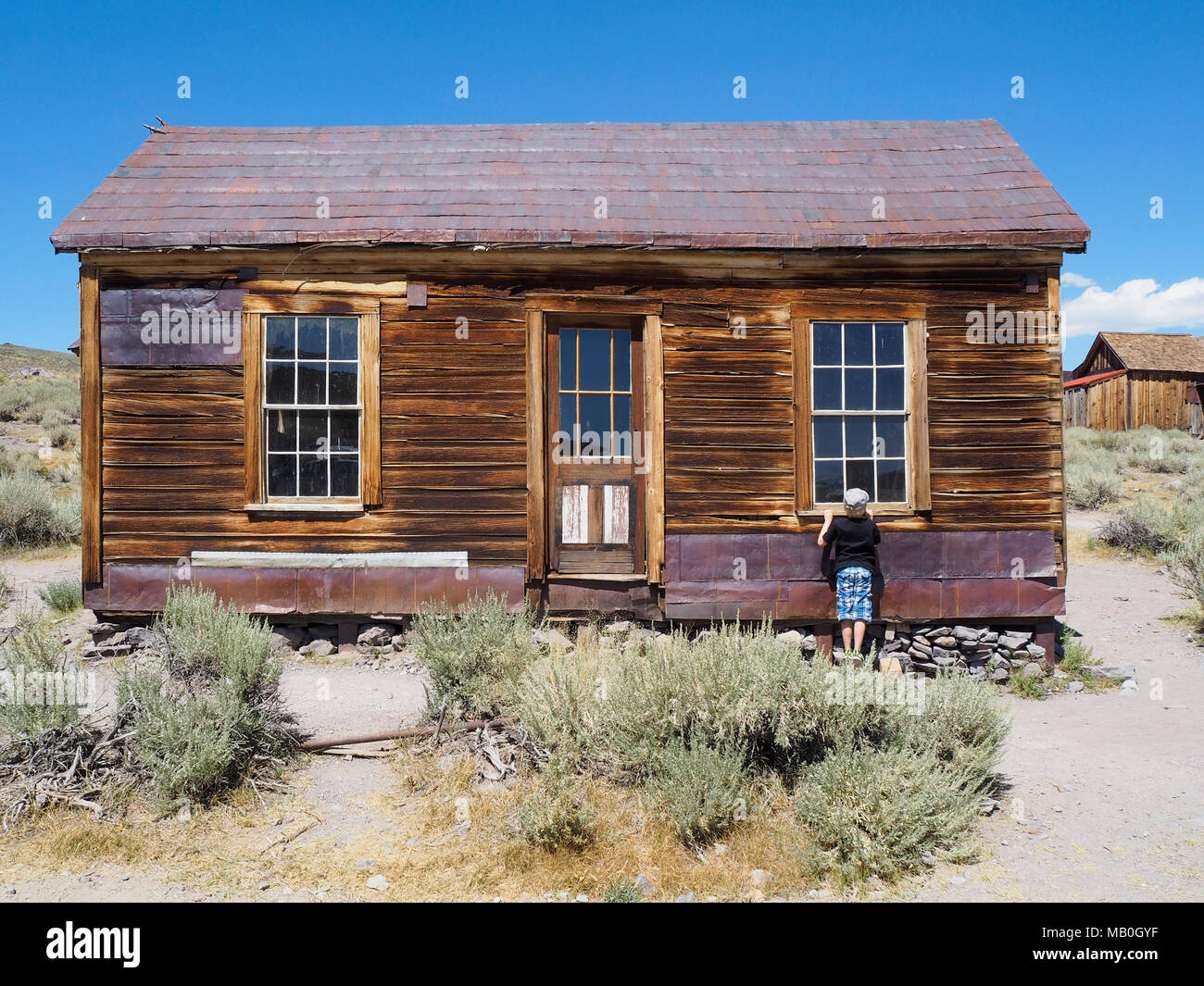 Bodie, CA (USA) - 10. August 2016: ein Tourist junge Späht in einem verlassenen Gebäude in Bodie State Historic Park, einem ehemaligen Wilden Westen der Stadt. Stockfoto