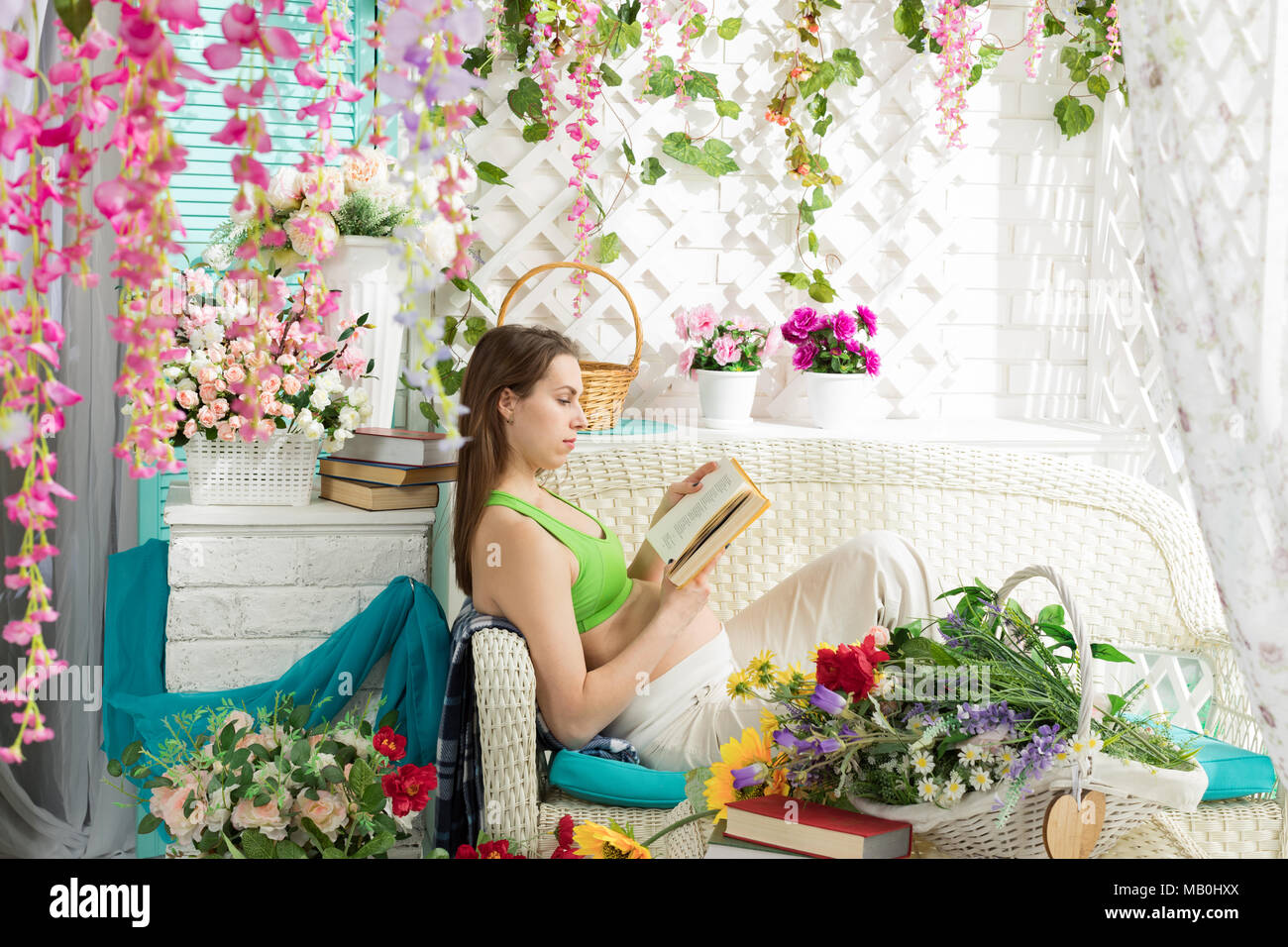 Junge schwangere Frau mit einem Buch in eine Sommerterrasse Stockfoto