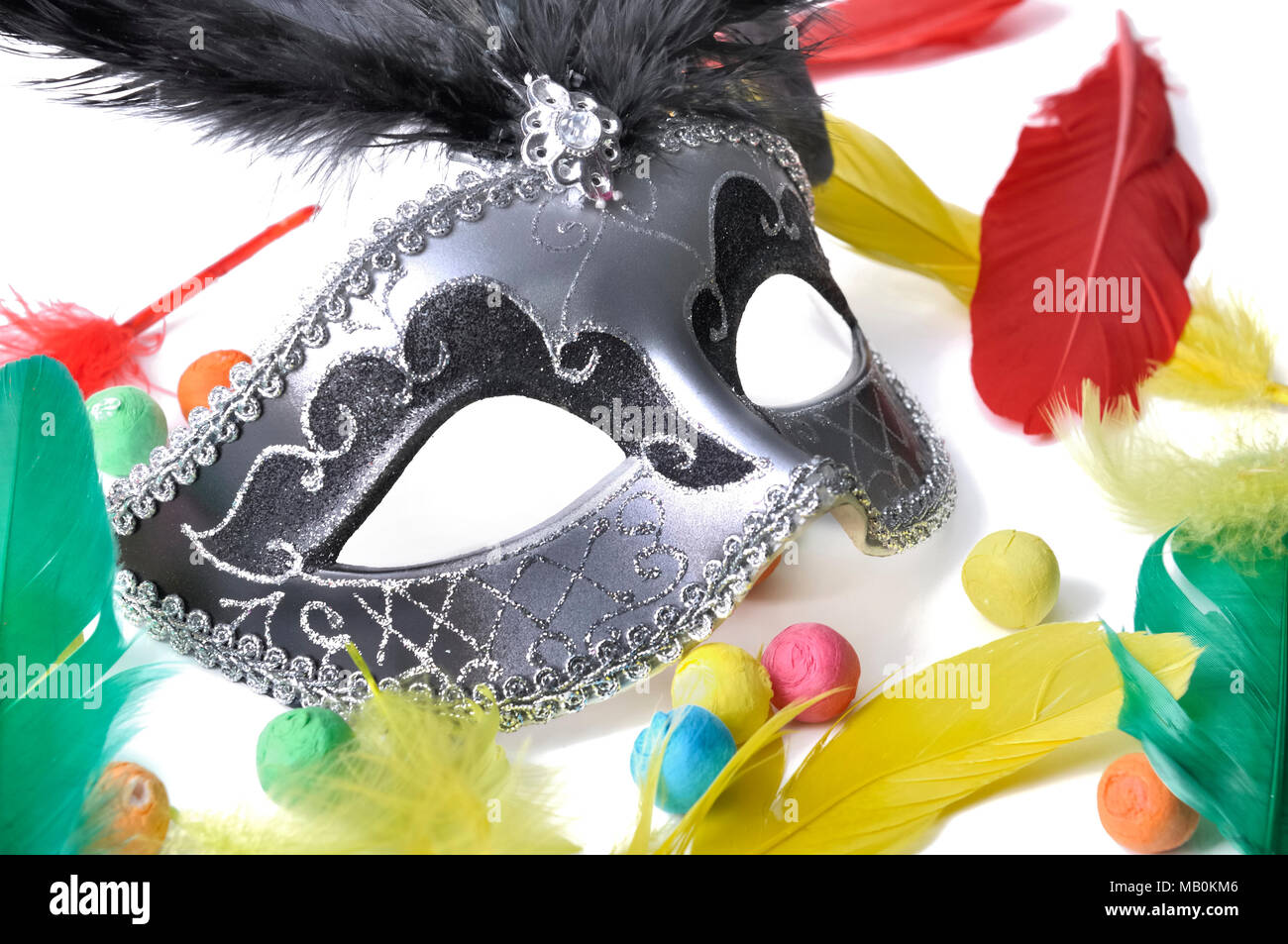Dunkle schöne Karneval Maske unter bunten Federn und Kugeln auf weißem Papier backgroung Stockfoto
