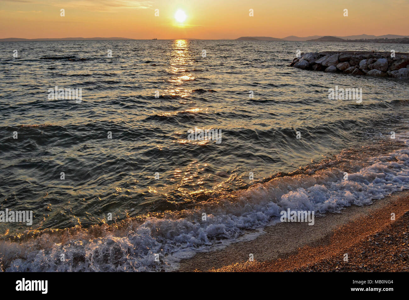 Kleine Wellen an der Küste während der Goldenen Stunde entlang der Küste kommen. Eine kühne und dramatische Szene von Blau, frisches Wasser. Horizontale, kopieren. Stockfoto