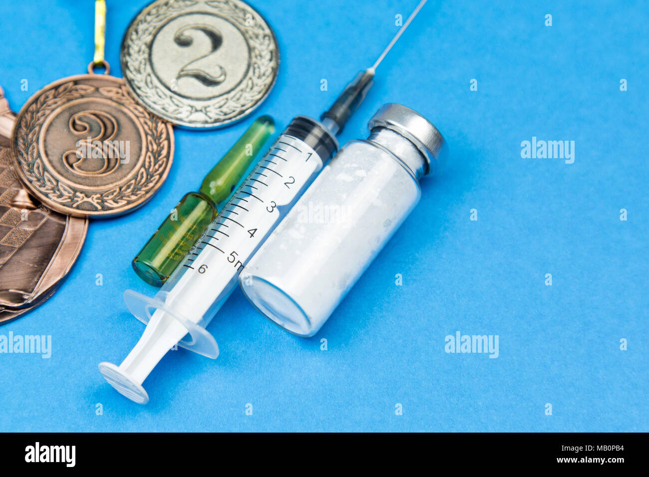 Verbotenen Drogen athletische Leistung im Wettbewerb zu erhöhen. Die Spritze, die Medizin, die auf einem blauen Hintergrund. Stockfoto