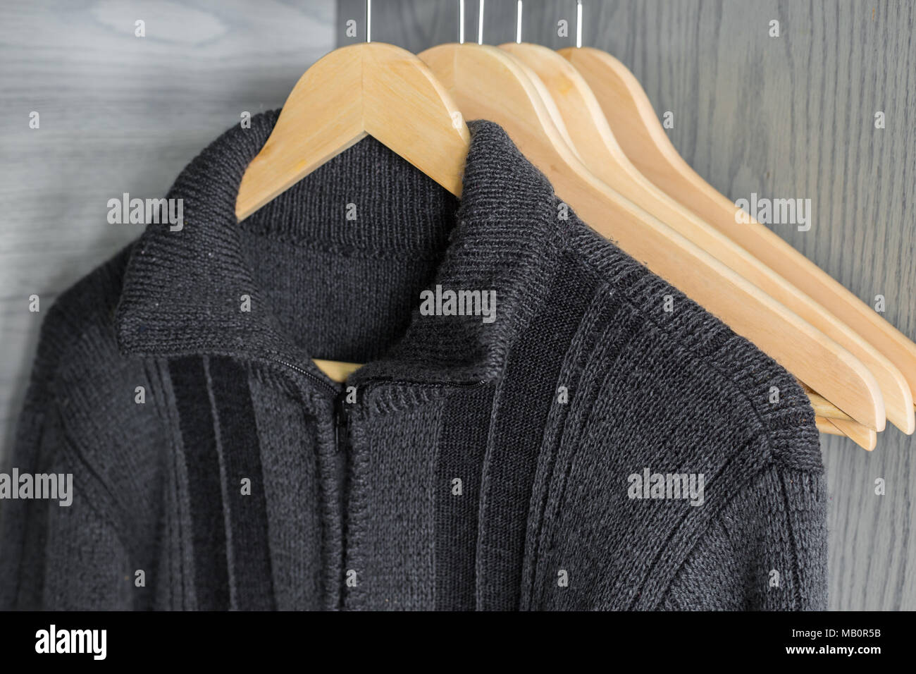 Ein Aufhänger mit Sachen. Gestrickte Pullover hängen auf Kleiderbügeln. Hellen Pullover. Frühling Kleidung. Stockfoto