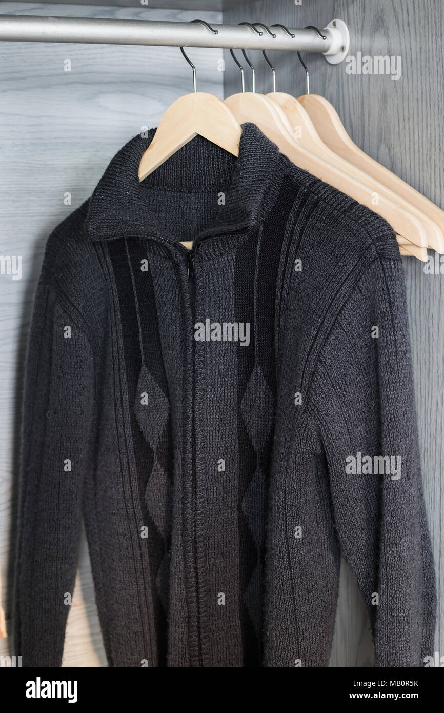 Ein Aufhänger mit Sachen. Gestrickte Pullover hängen auf Kleiderbügeln. Hellen Pullover. Frühling Kleidung. Stockfoto
