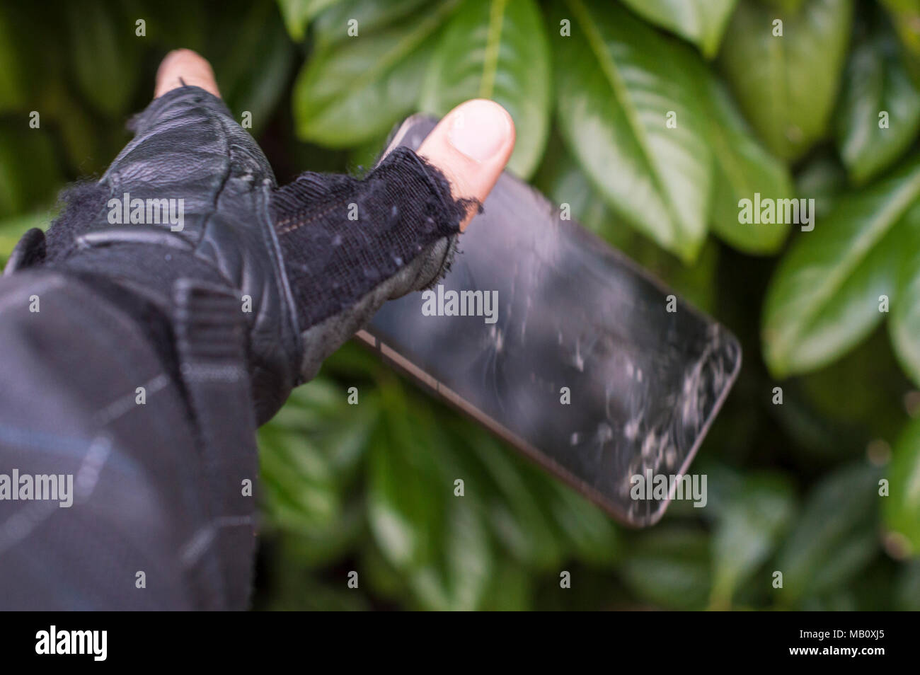 Gebrochen-Smartphone ist mit der Masse von der Hand gestartet Stockfoto