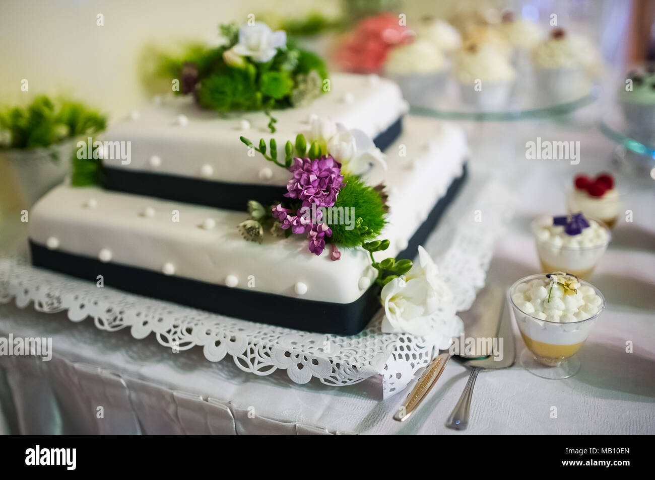 Hochzeitstorte mit Blumen Dekor und weiße Zuckerglasur Stockfoto