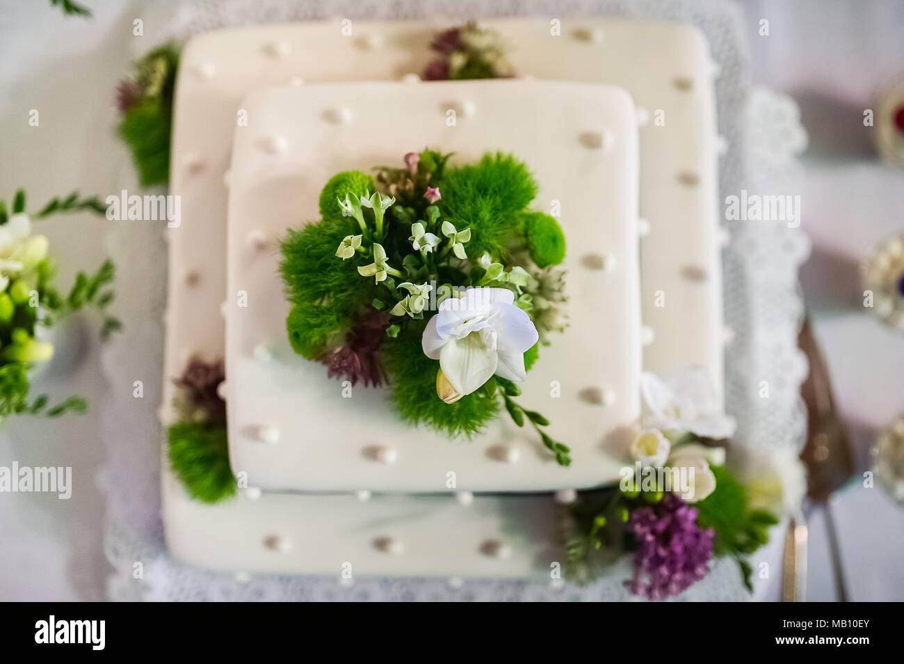 Hochzeitstorte mit Blumen Dekor und weiße Zuckerglasur Stockfoto