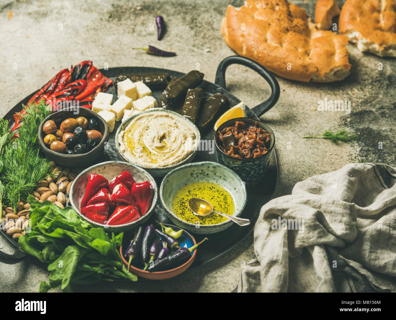 Mittelmeerraum, Naher und Mittlerer Osten meze starter Platter. Gefüllte eingelegte Paprika, Dolma, Hummus, gewürzten Öl, Oliven, getrocknete Tomaten, Nüsse, Käse, flach Stockfoto