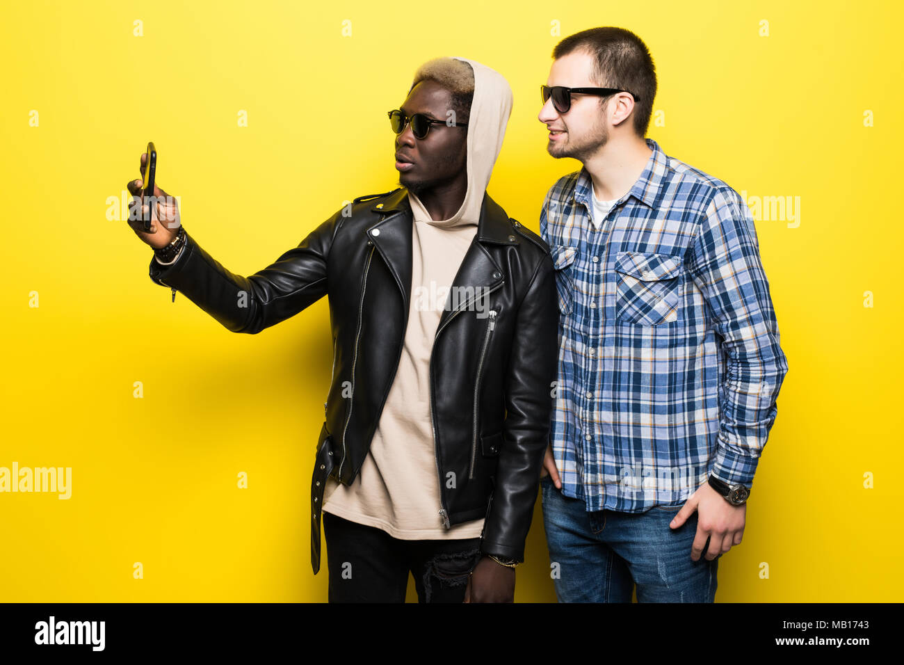 Zwei besten multirassischen Freunde unter selfie mit Handy Kamera auf gelbem Hintergrund. Stockfoto