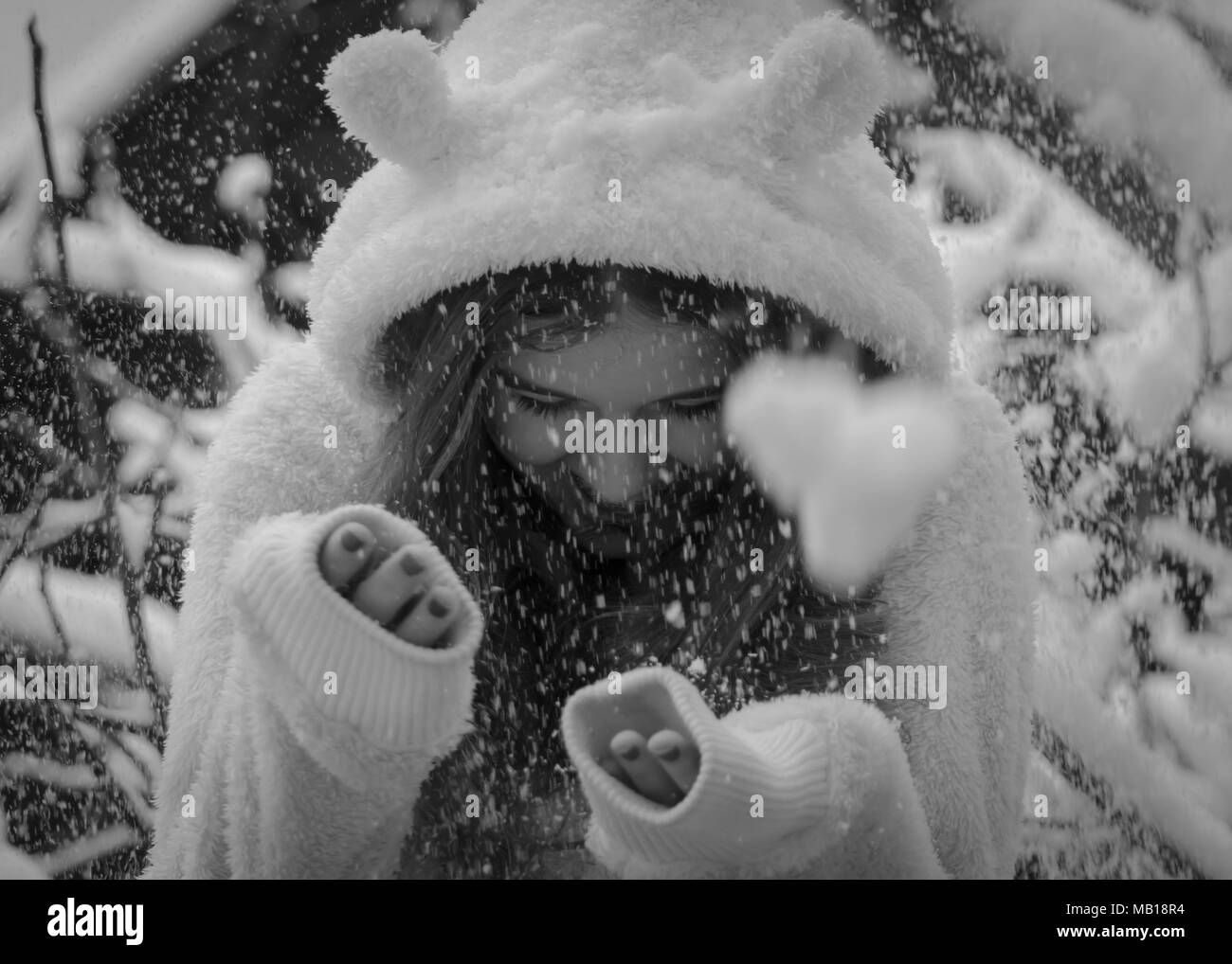 Portrait von niedlichen Happy teenage Mädchen im Schnee, Schwarz und Weiß. Closeup schöne jugendlich Mädchen, lange Haare, weißes Fell, lächelnd im Schnee. Winter Thema. Stockfoto