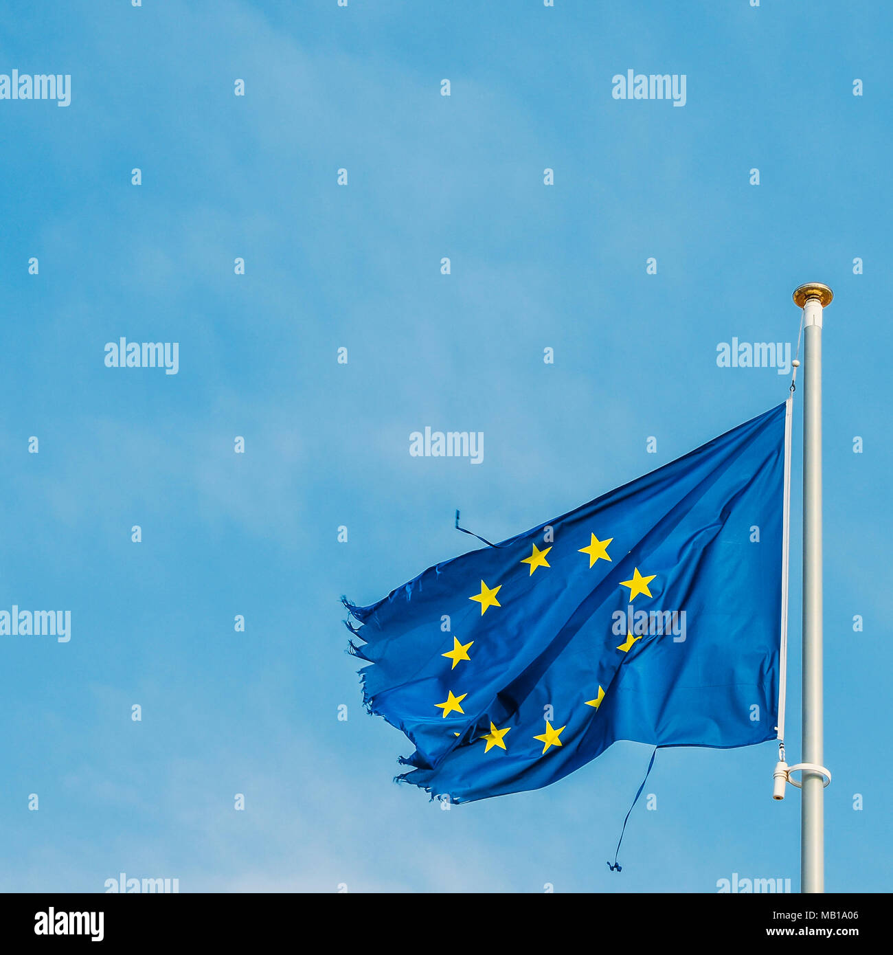 Fahne der Europäischen Union auf einem Mast stolz im Wind bewegen trotz der zerrissen Stücke Stoff an den Rändern der vielleicht eine Metapher für die schwere Krise derzeit die wirtschaftlichen Block. Stockfoto