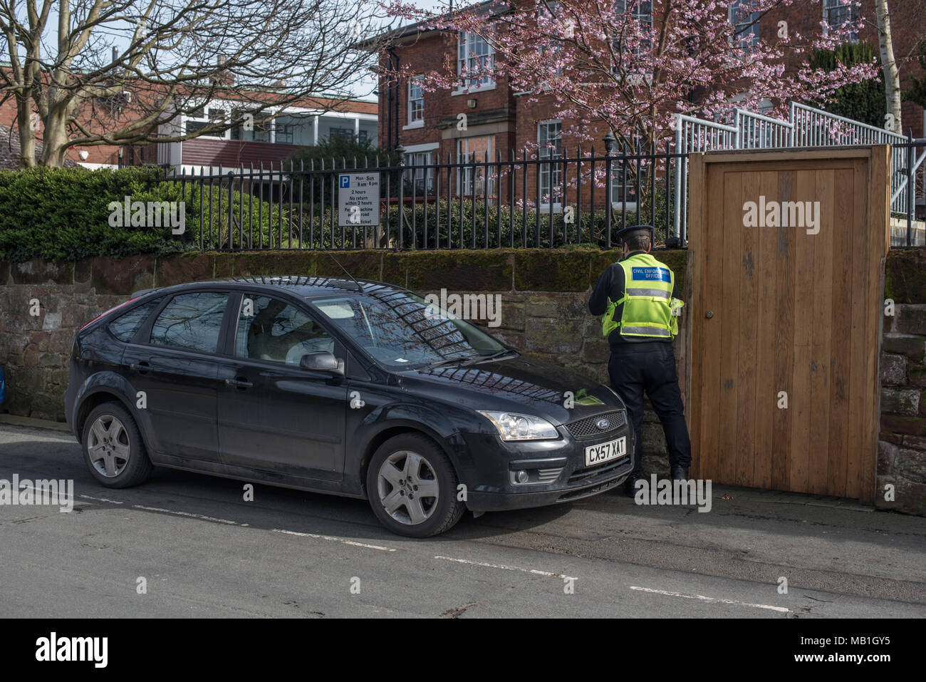 Parken Wärter gibt heraus ein Ticket auf einem städtischen Back Street in Shrewsbury, in der Nähe des Steinbruchs Park Stockfoto