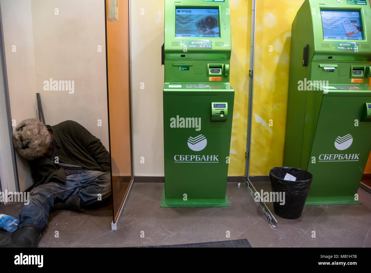 Ein armer Mann schläft im ATM-Zimmer der Sberbank Zweig von Russland in Moskau Stockfoto