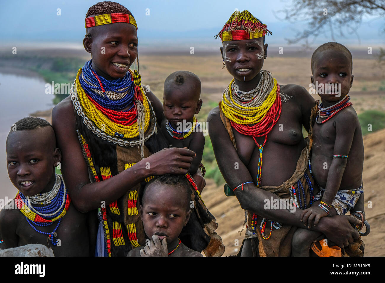 Omo Valley, Äthiopien - Januar 26, 2018: Unbekannter Karo Frauen und ihre Kinder mit Omo Fluss im Hintergrund im Omo Valley, Äthiopien. Stockfoto
