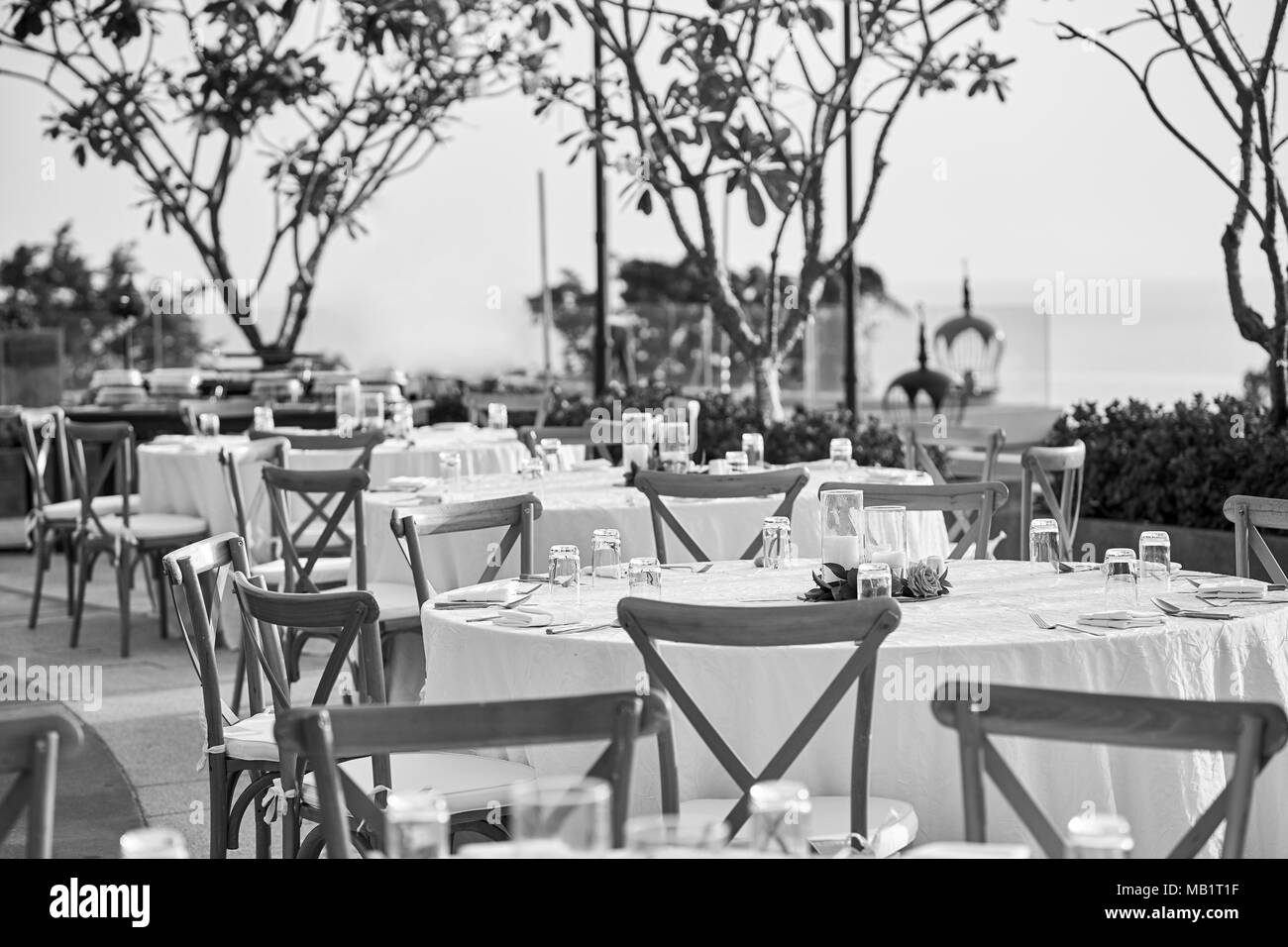 Die Schwarzen und Weißen der Hochzeit Dinner Table Setup, mit dem Modernen klappbarer Liegestühle. Das leere Glas und Platz auf dem Tisch, die Kerze ein Stockfoto