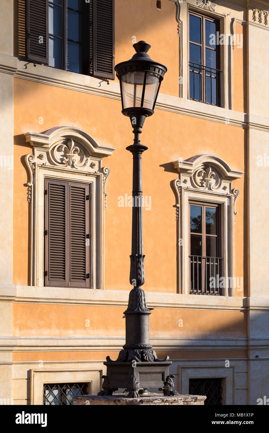 Eine Straßenlaterne in Piazza di Spagna, Rom, Italien. Wie die untergehende Sonne genommen schafft gewinkelt Schatten über die pastellfarbenen Gebäuden, das Licht (wie Stockfoto