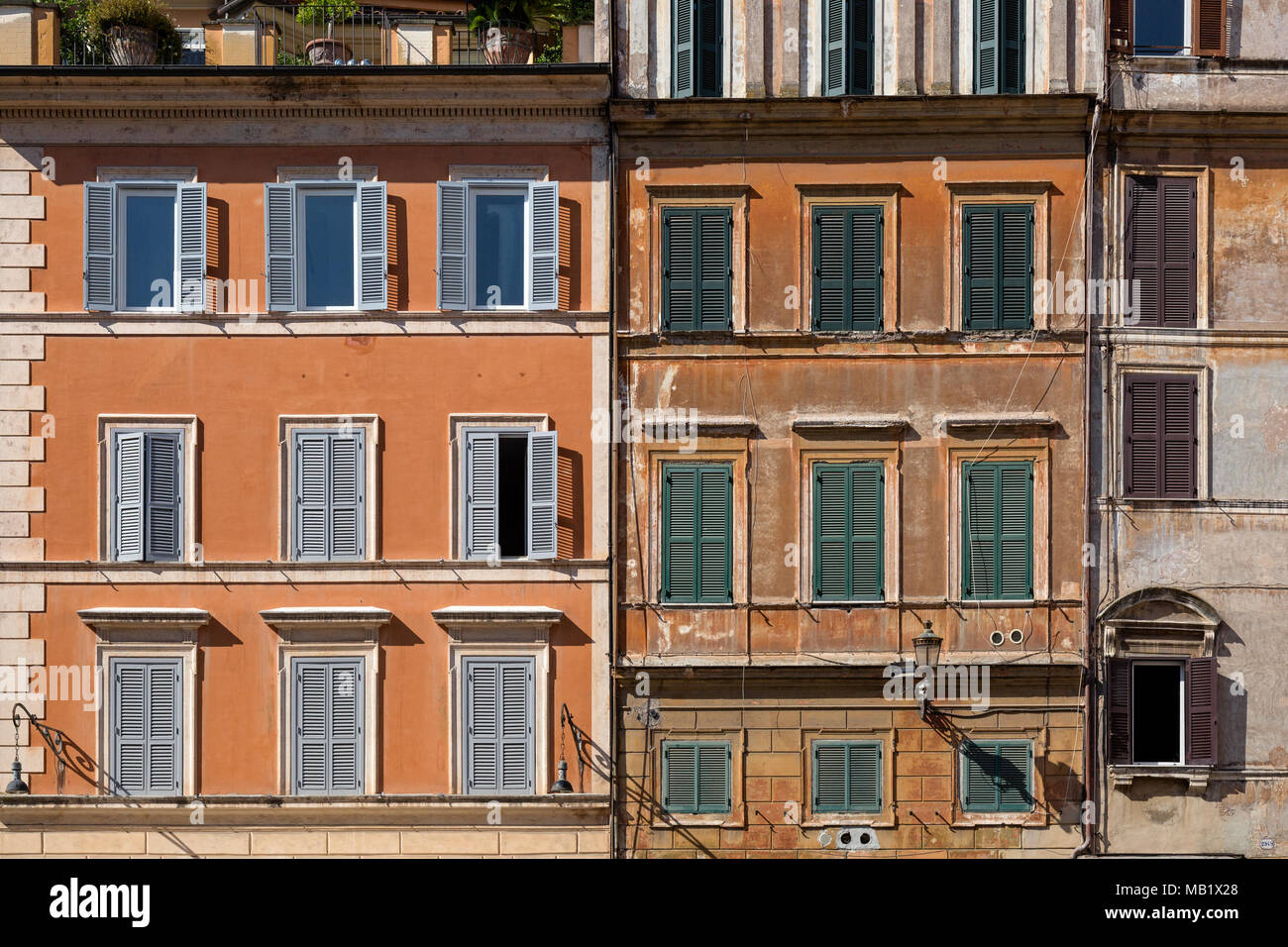 Fenster und Rollläden auf die verwitterte Fassade der Gebäude in Rom, Italien, an einem sonnigen Tag im August. Stockfoto