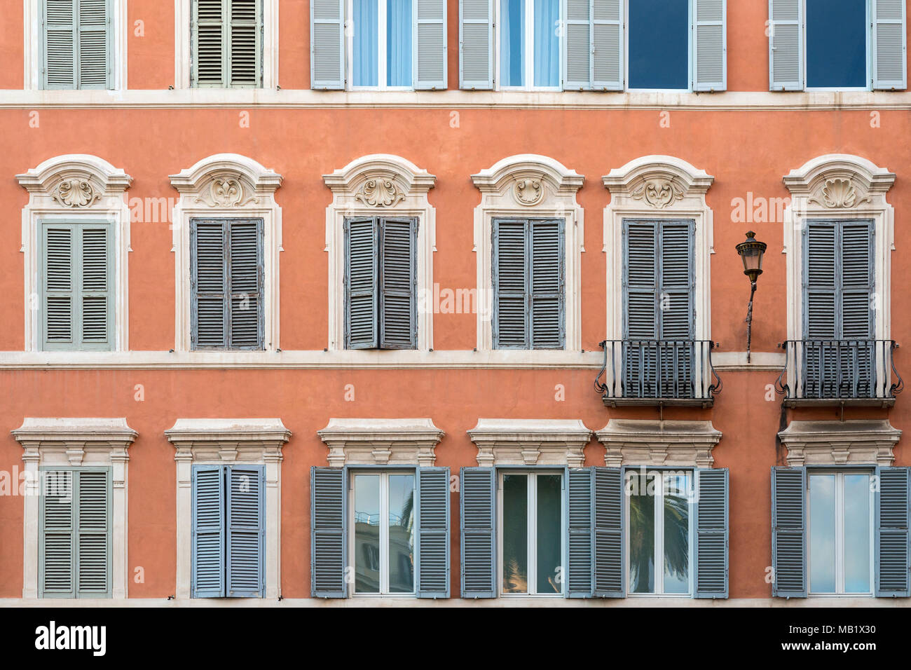 Fenster und Rollläden auf einem terrakottafarbenen Gebäude in Piazza di Spagna, Rom, Italien. Stockfoto