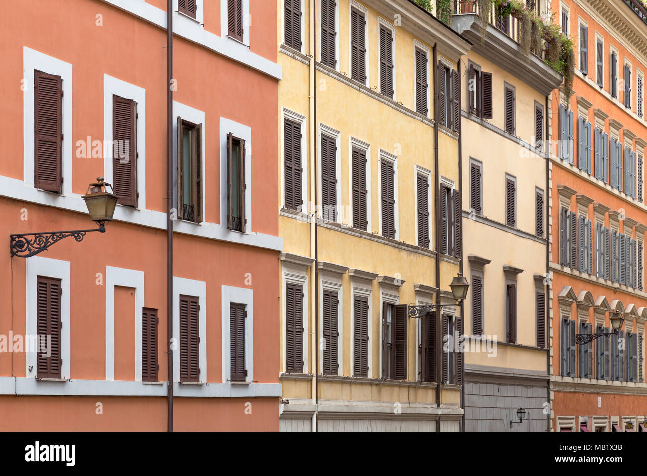 Töne von Orange und Gelb die Wände der bunten Gebäude in den Straßen von Rom, Italien schmücken. Stockfoto