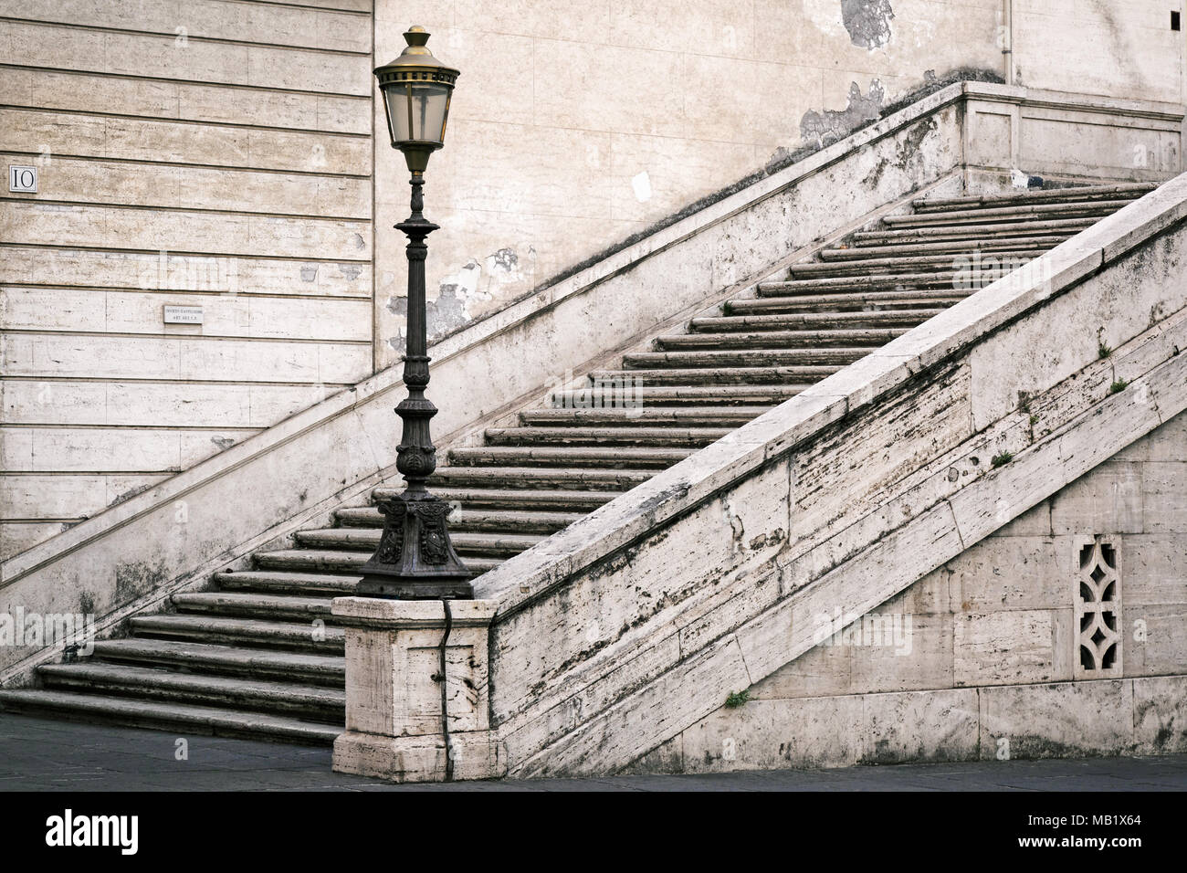 Schritte und eine reich verzierte Straßenlaterne in Rom, Italien. An der Wand eine kleine Plakette liest 'Divieto d'Affissione", das bedeutet etwa "Poster Prohib übersetzt Stockfoto