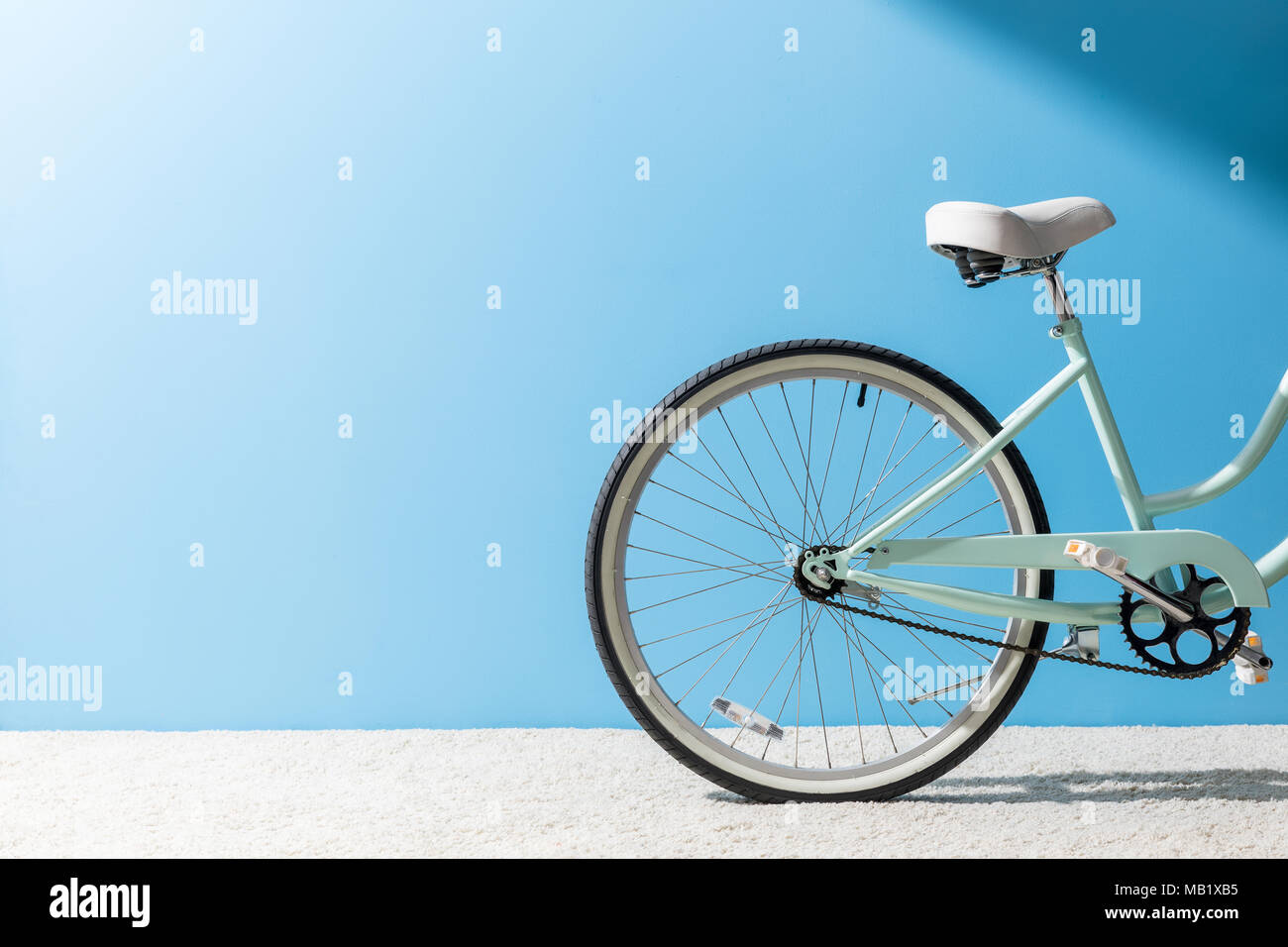 Zurück Rad Fahrrad stehend auf dem Teppich vor der blauen Wand Stockfoto