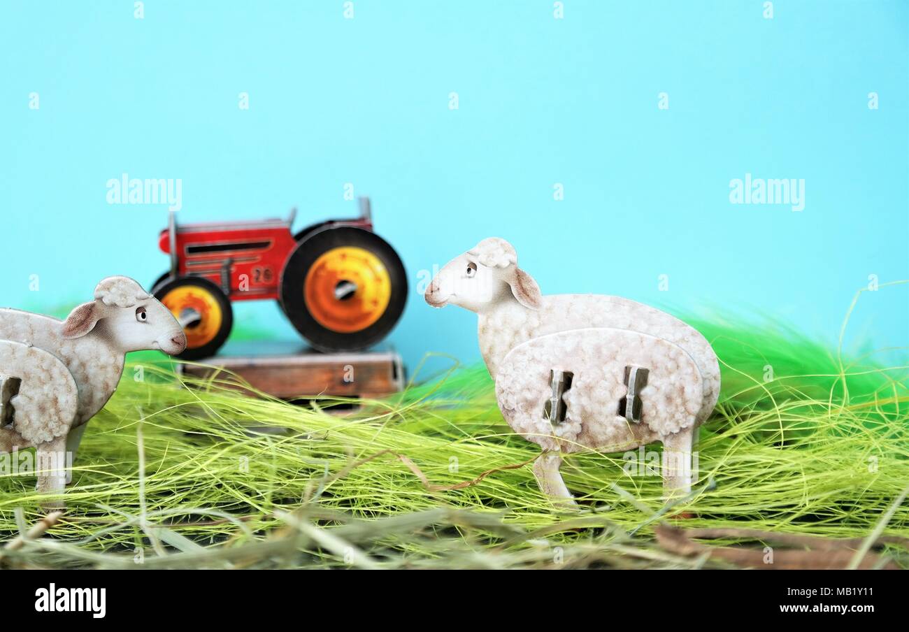 Zwei Schafe und einem Traktor. Nutztiere mit grünen und blauen Hintergrund. kleinen Karton Spielwaren für Kinder und Kopieren. Stockfoto