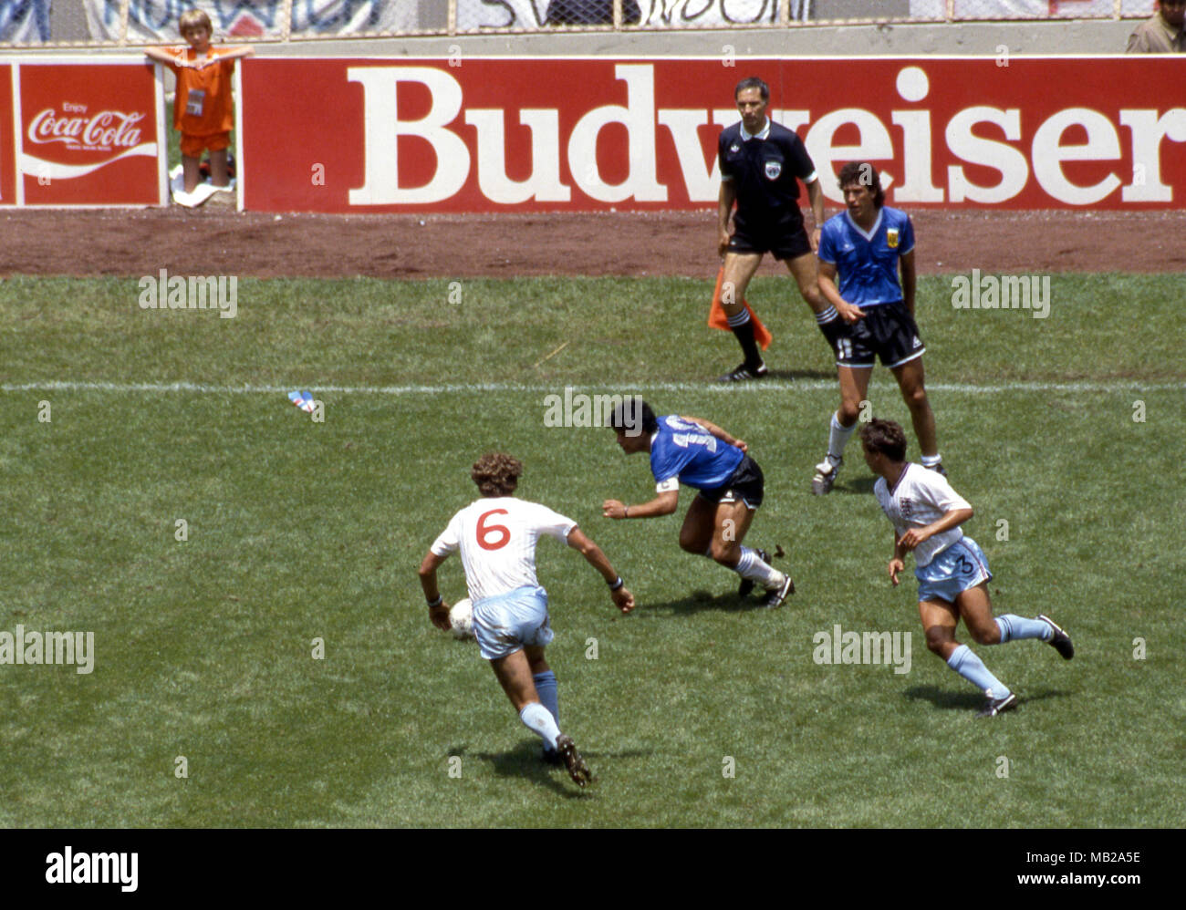 FIFA WM - Mexiko 1986 22.6.1986, Estadio Azteca, Mexico, D.F. Viertelfinale Argentina v England. Diego Maradona (Argentinien) v Terry Butcher (6) und Kenny Sansom (England). Auf dem Hintergrund Jorge Valdano und die Bulgarische linienrichter Bogdan Dotchev. Stockfoto
