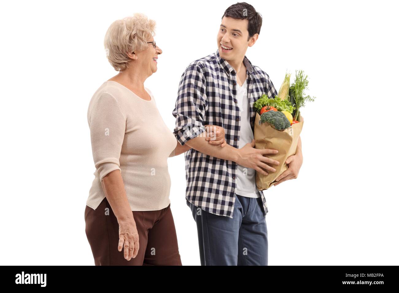 Junger Mann helfen, eine ältere Frau mit ihrer Lebensmittel auf weißem Hintergrund Stockfoto