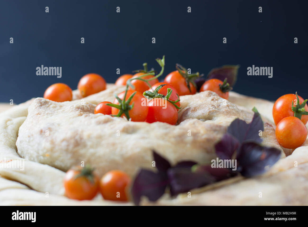 Spirale filo Pie burek mit Kirschtomaten auf hölzernen Tisch Stockfoto