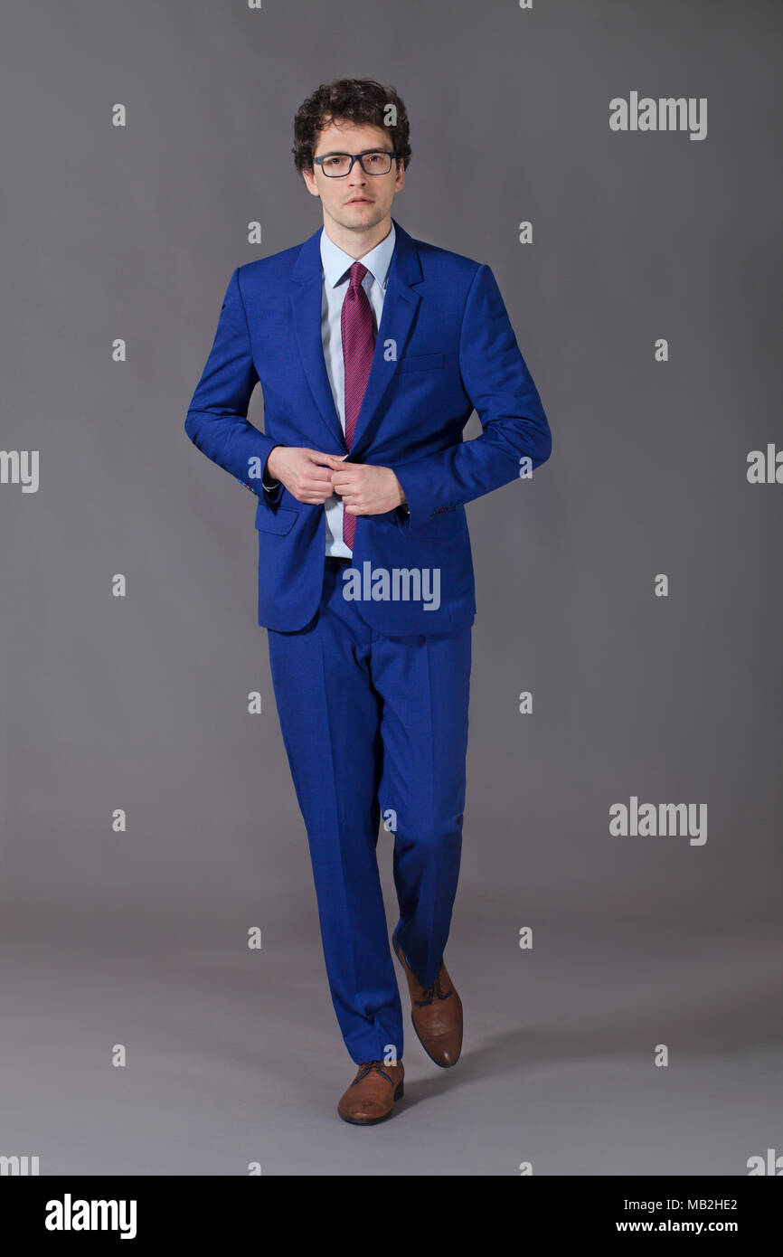 Junge kinky Mann, schritt und knöpfte seine blaue Jacke Stockfoto