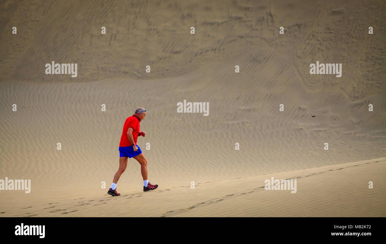 Ältere Mann läuft durch die Maspalomas Wüste. Stockfoto