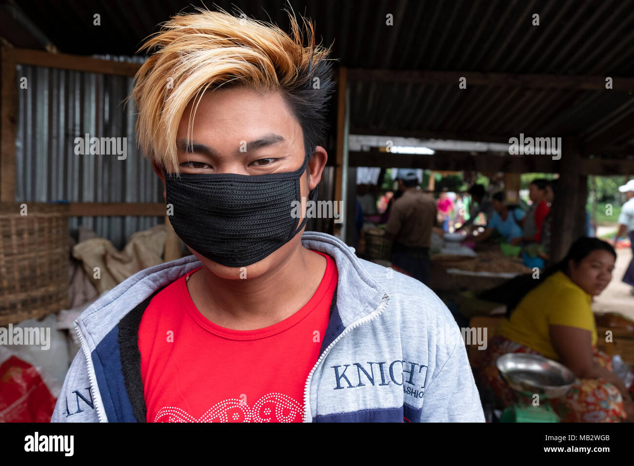 Ein junger Mann trägt eine Maske, die Ausbreitung von Keimen an der Demoso Markt in Kayin State zu verhindern, Myanmar Stockfoto