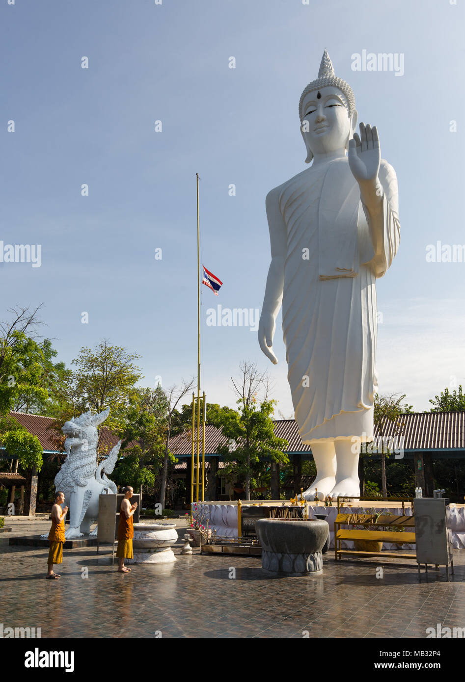 Mönche vor einer riesigen Buddha-statue im Wat Pa Thamma Utthayan, Khon Kaen, Isan, Thailand Stockfoto