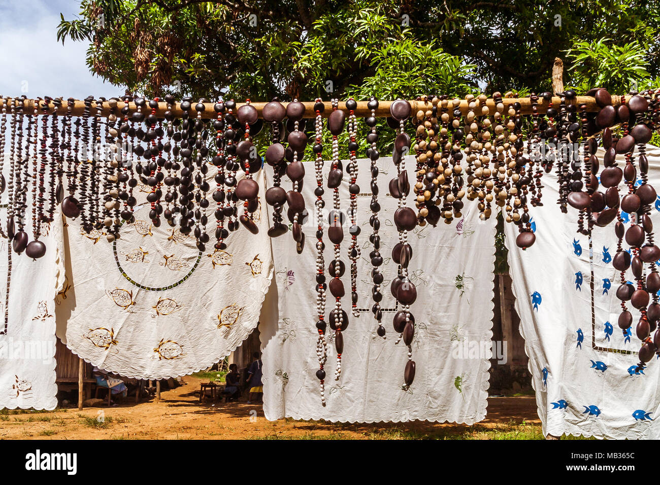Handwerk, gestickte Tischdecken und Halsketten Samen in Nosy Komba (Nosy Be), Madagaskar Stockfoto