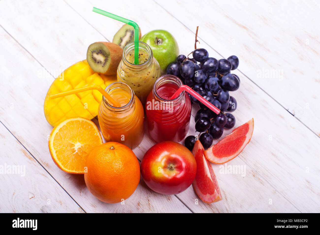 Zeile frische Säfte Smoothie drei Flaschen Rot Grün Orange Früchte Vitamine gesunde Konzept auf Weiß. Stockfoto