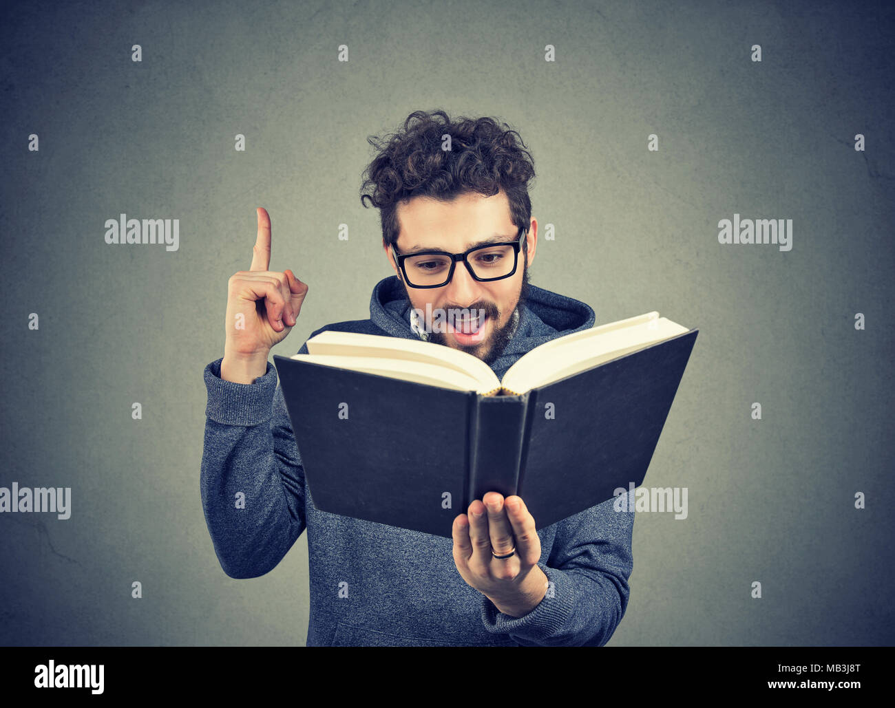 Aufgeregt hipster Kerl mit einem Buch hat eine gute Idee Stockfoto